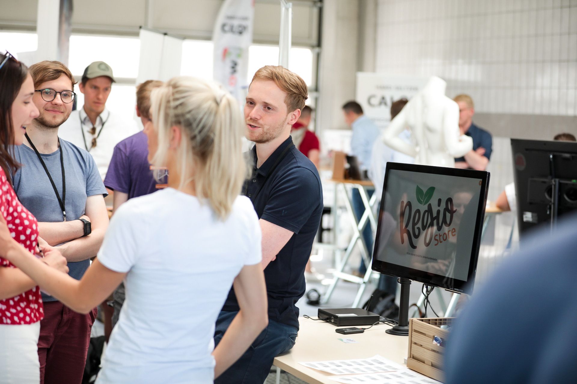 Menschen im Gespräch am RegioShopper Stand auf der Innovate Messe